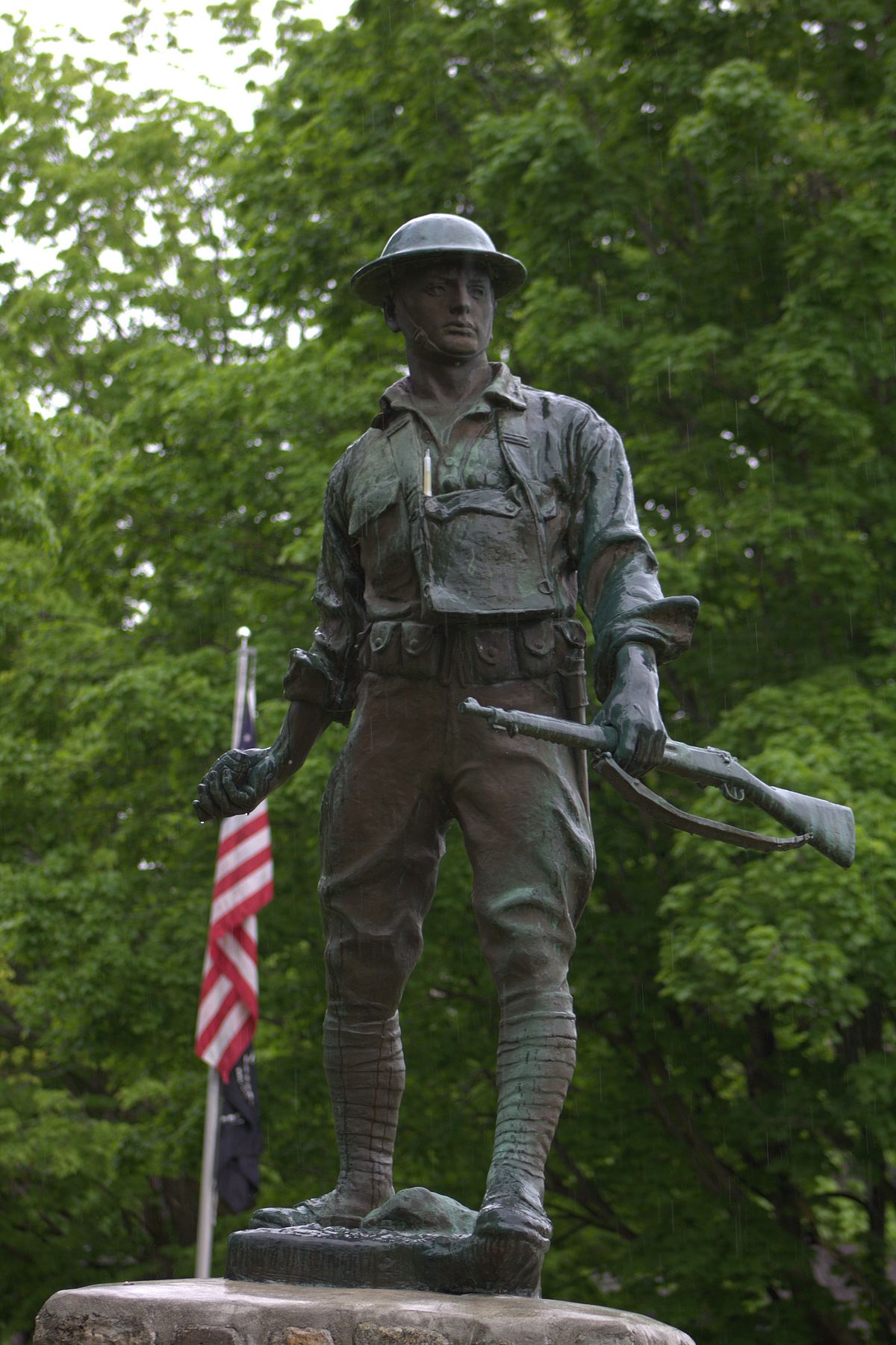 Statue of soldier in front of American Flag